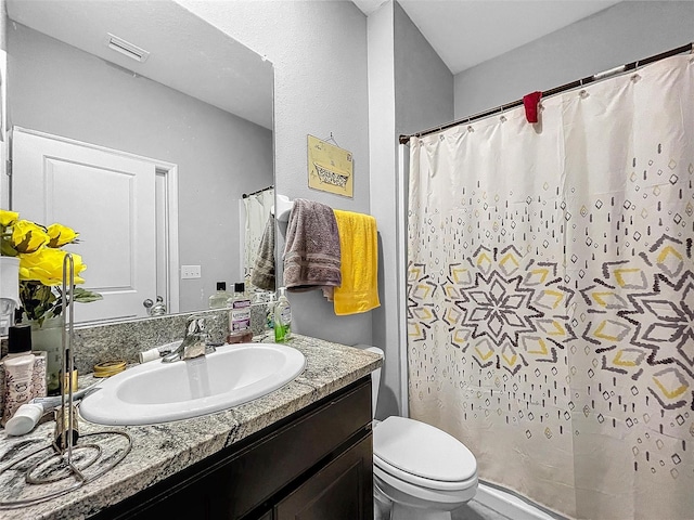 full bath with visible vents, a shower with shower curtain, vanity, and toilet