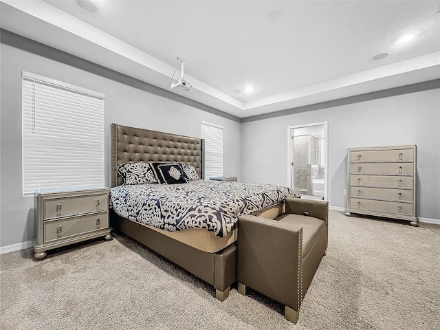 bedroom with baseboards, ensuite bath, a tray ceiling, carpet flooring, and recessed lighting