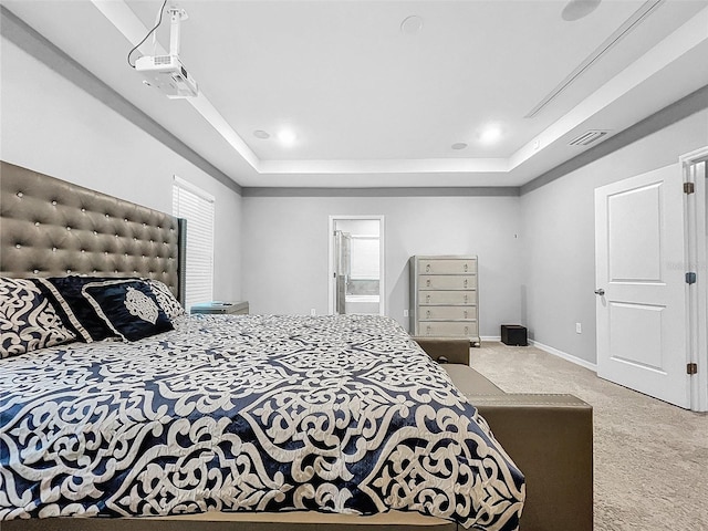 bedroom with a tray ceiling, carpet flooring, visible vents, and baseboards