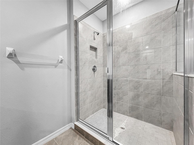 full bathroom featuring a stall shower, baseboards, and tile patterned floors