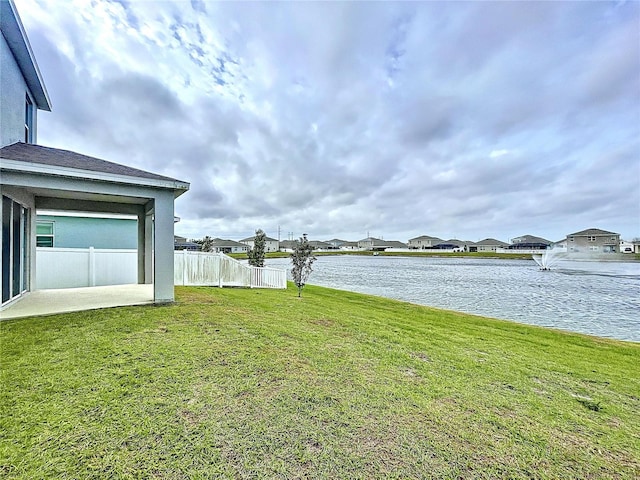 view of yard with a water view and fence