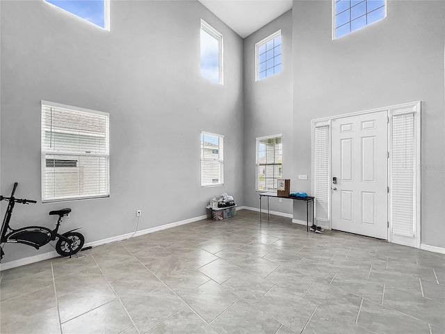 tiled foyer featuring plenty of natural light and baseboards