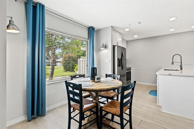 dining space featuring sink and a textured ceiling