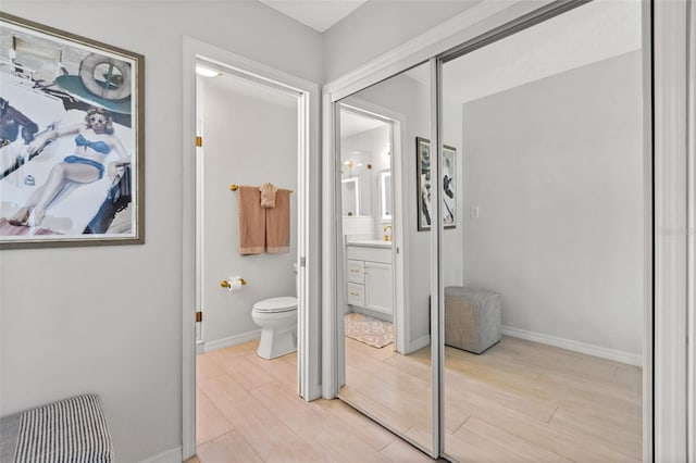 bathroom featuring toilet, hardwood / wood-style floors, and vanity