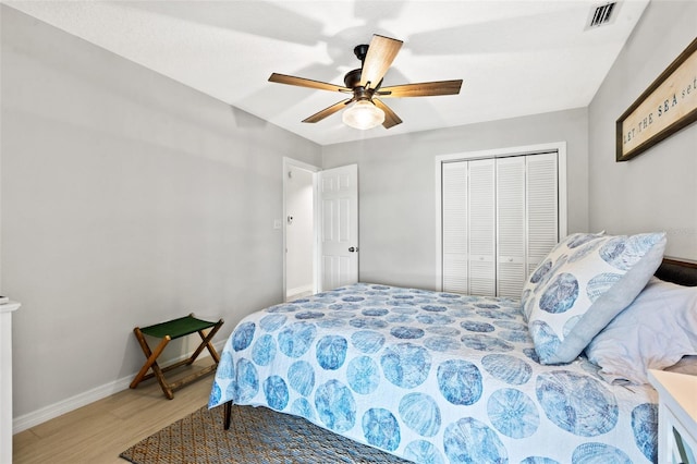 bedroom with ceiling fan, a closet, and light hardwood / wood-style floors