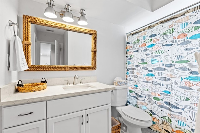 bathroom featuring toilet, vanity, and walk in shower