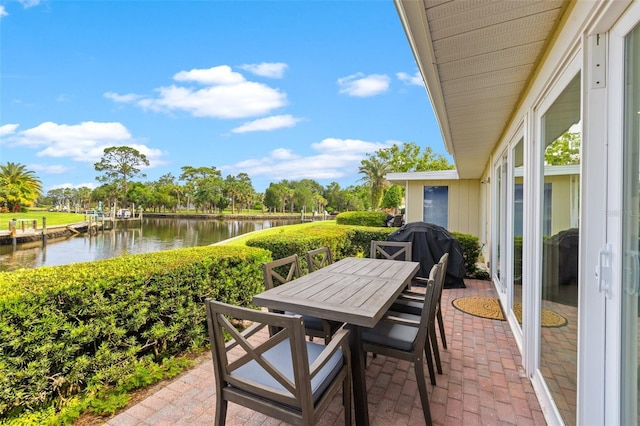 view of patio with a grill and a water view