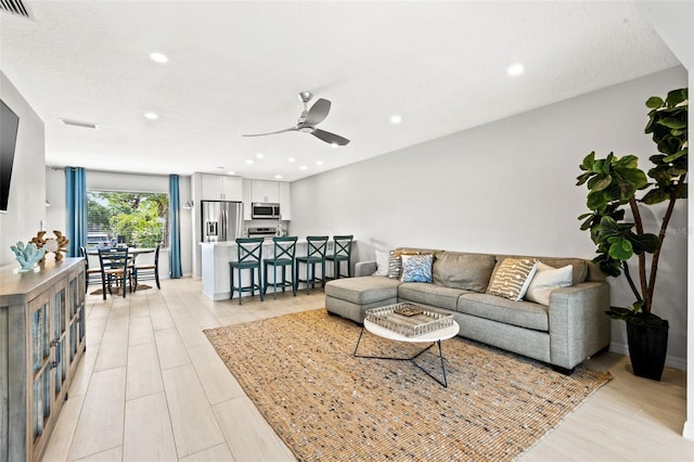 living room featuring ceiling fan and light hardwood / wood-style floors