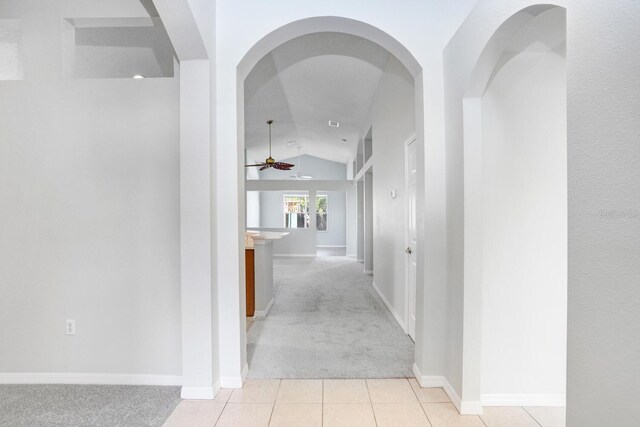 hall with vaulted ceiling and light colored carpet