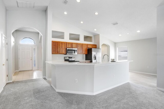 kitchen with high vaulted ceiling, light colored carpet, and stainless steel appliances