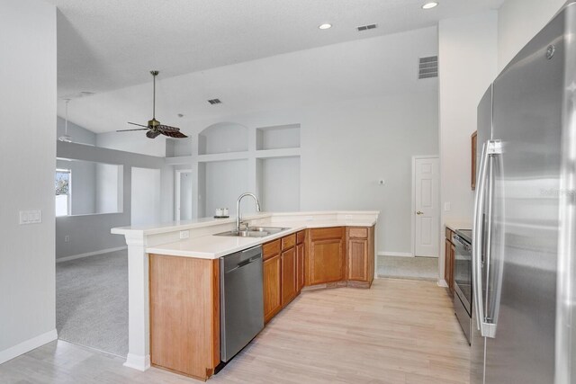 kitchen featuring stainless steel appliances, sink, light wood-type flooring, and ceiling fan