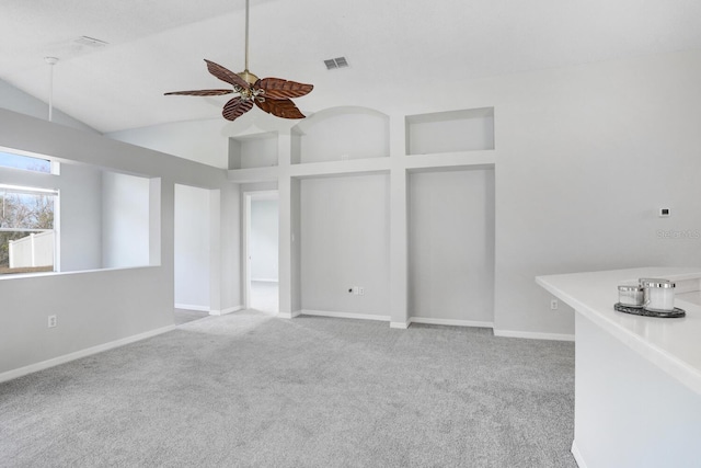 interior space featuring visible vents, baseboards, carpet floors, high vaulted ceiling, and a ceiling fan