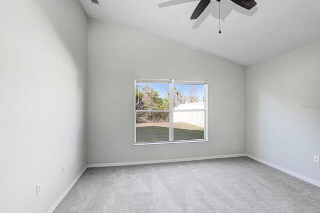 spare room with a textured ceiling, carpet, ceiling fan, and vaulted ceiling