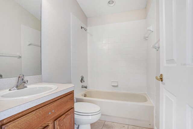 full bathroom with tile patterned flooring, tiled shower / bath, toilet, and vanity