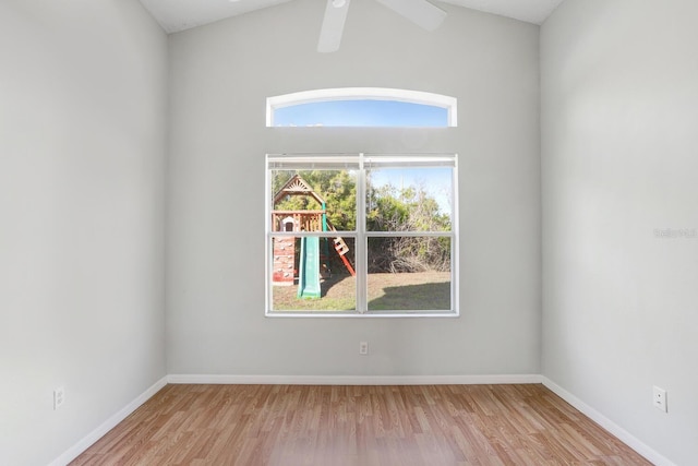 spare room with baseboards, wood finished floors, and a ceiling fan