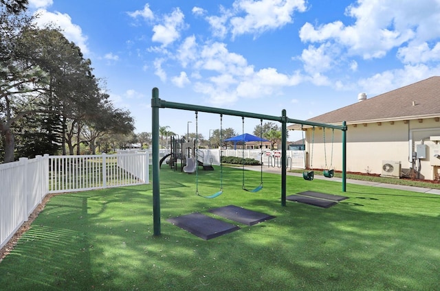 community play area with ac unit, a lawn, and fence