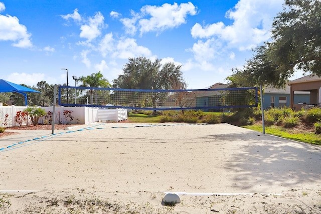 view of property's community featuring volleyball court and fence