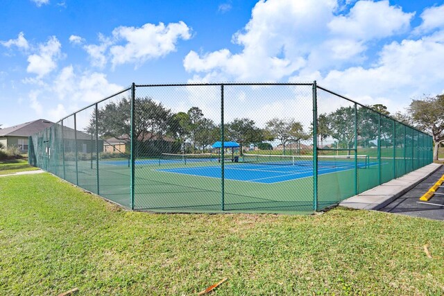 view of tennis court featuring a lawn