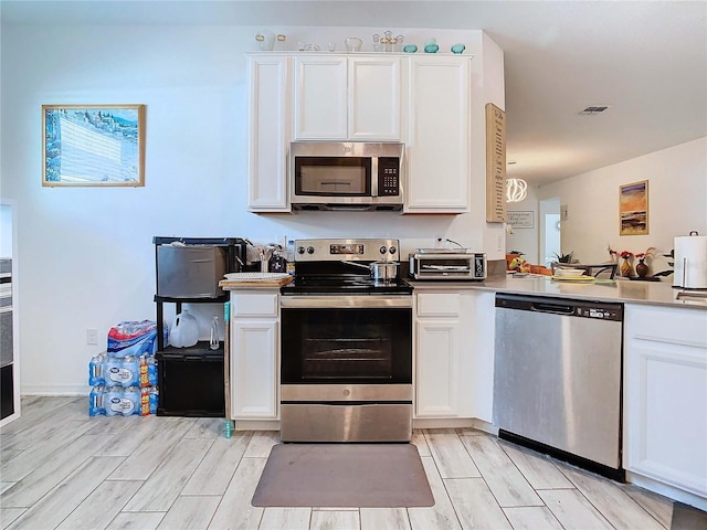 kitchen with appliances with stainless steel finishes and white cabinets