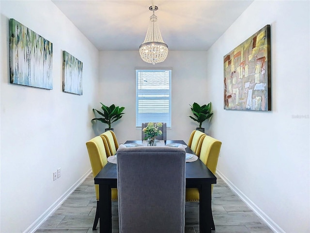 dining space featuring hardwood / wood-style flooring and an inviting chandelier