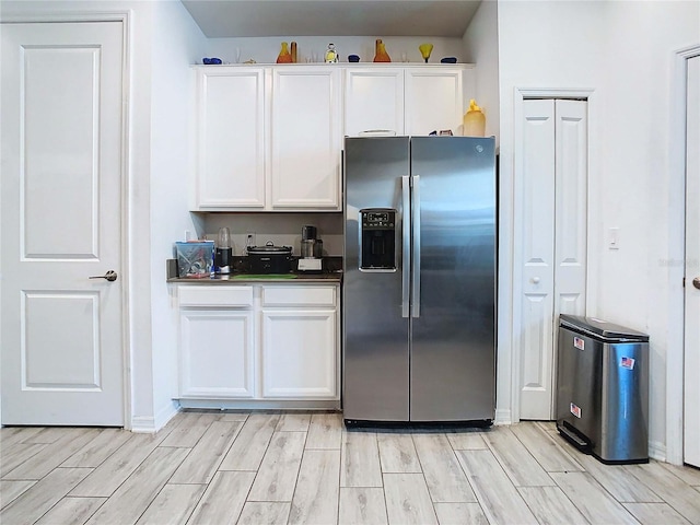 kitchen with white cabinetry and stainless steel fridge with ice dispenser