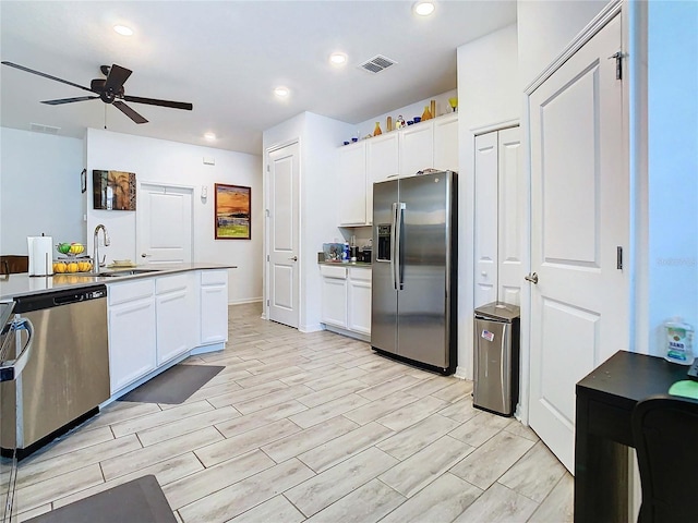 kitchen featuring ceiling fan, stainless steel appliances, sink, and white cabinets