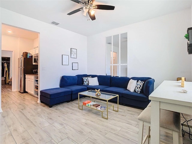 living room featuring ceiling fan and light hardwood / wood-style flooring