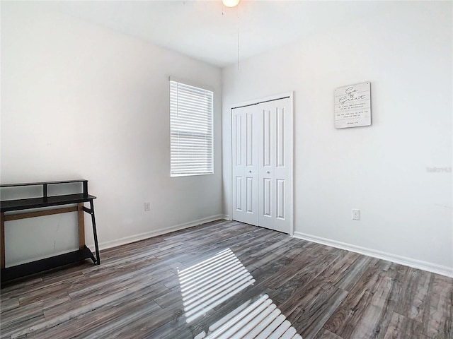 unfurnished bedroom with dark hardwood / wood-style flooring and a closet