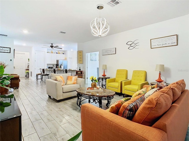 living room with ceiling fan with notable chandelier