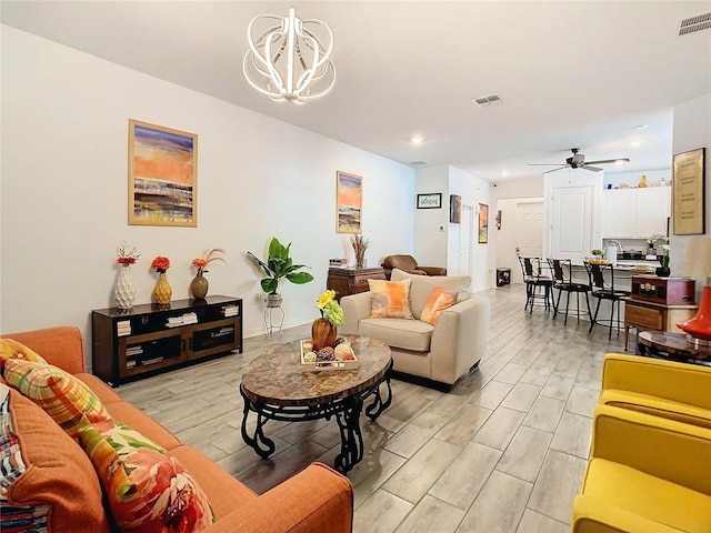 living room featuring ceiling fan with notable chandelier