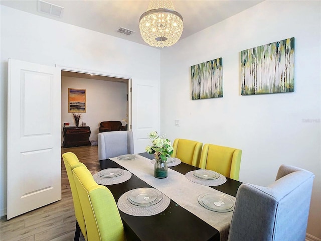 dining space featuring a notable chandelier and hardwood / wood-style flooring