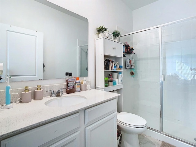 bathroom featuring a shower with door, vanity, and toilet