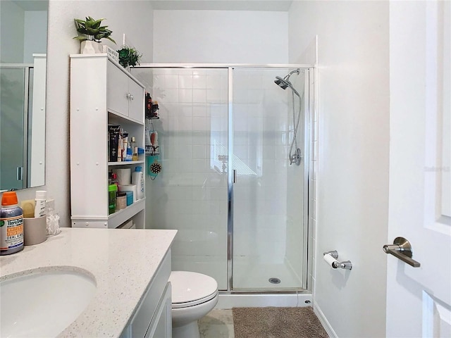 bathroom featuring vanity, toilet, and an enclosed shower