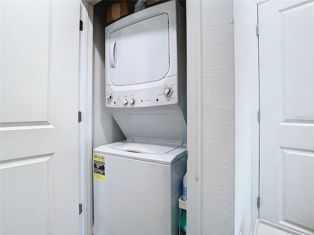 clothes washing area with stacked washer / dryer