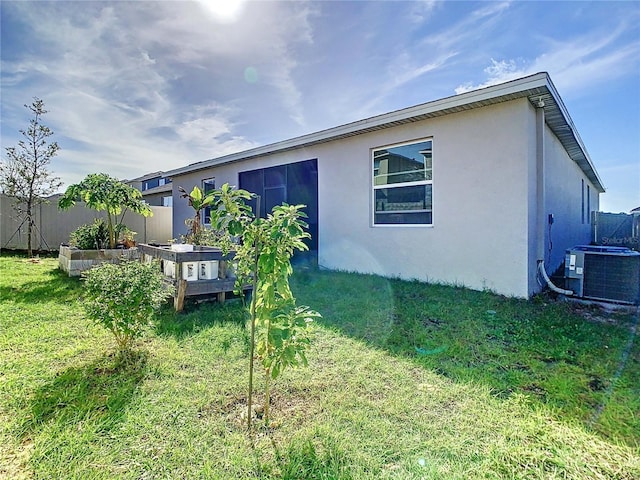 back of property featuring a yard and central air condition unit