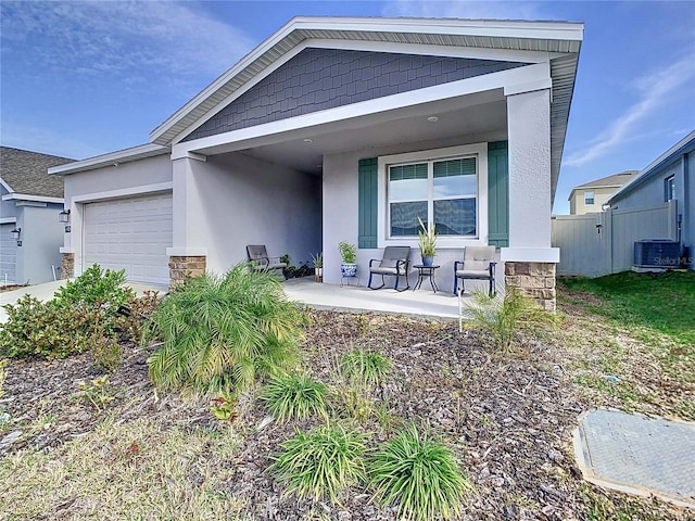 exterior space featuring a garage, central AC unit, and covered porch