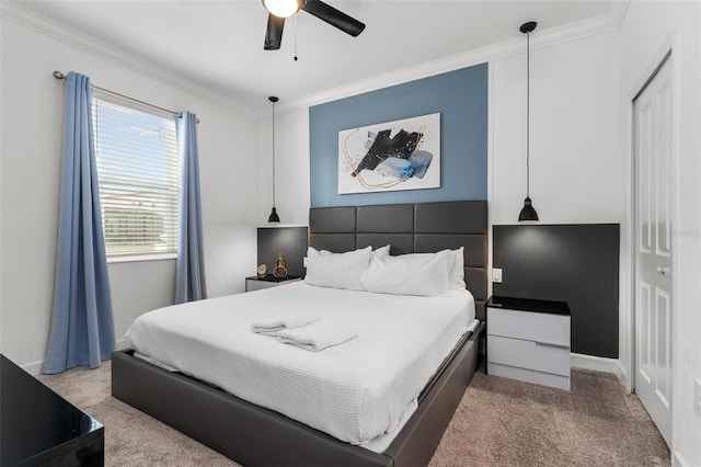 carpeted bedroom featuring a closet, ceiling fan, and ornamental molding