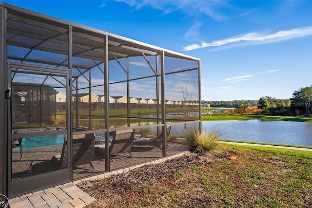 exterior space featuring glass enclosure, a water view, and a patio area