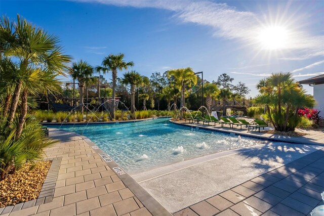 view of swimming pool with pool water feature and a patio area