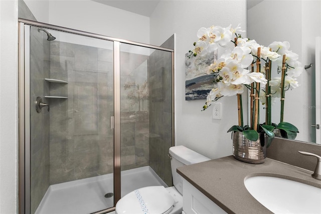 bathroom featuring a stall shower, toilet, and vanity