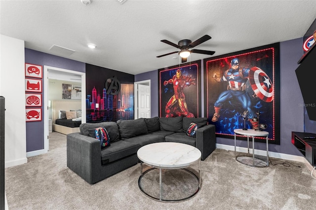 living room with a textured ceiling, carpet floors, ceiling fan, and baseboards