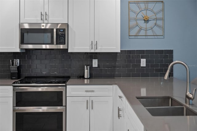 kitchen featuring appliances with stainless steel finishes, decorative backsplash, and white cabinetry