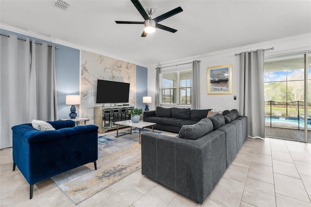 living room with a ceiling fan, visible vents, crown molding, and light tile patterned floors