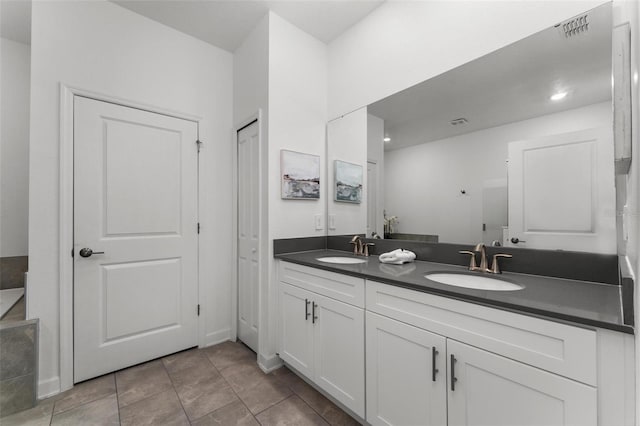 full bathroom with a sink, double vanity, visible vents, and a closet