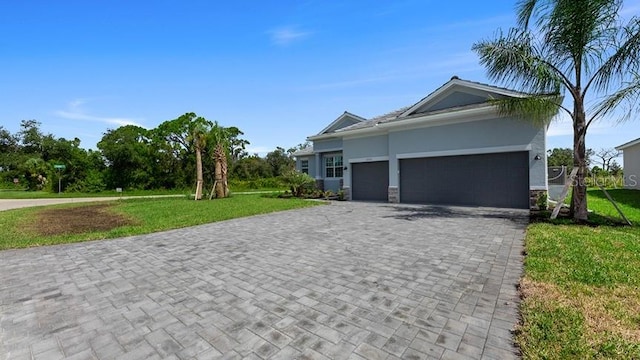 view of front of property featuring stone siding, an attached garage, decorative driveway, and a front lawn