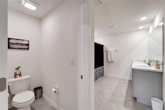 bathroom with tile patterned flooring, toilet, and vanity