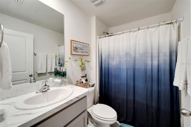 bathroom with vanity, a textured ceiling, and toilet