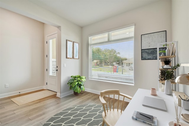 home office with light hardwood / wood-style flooring