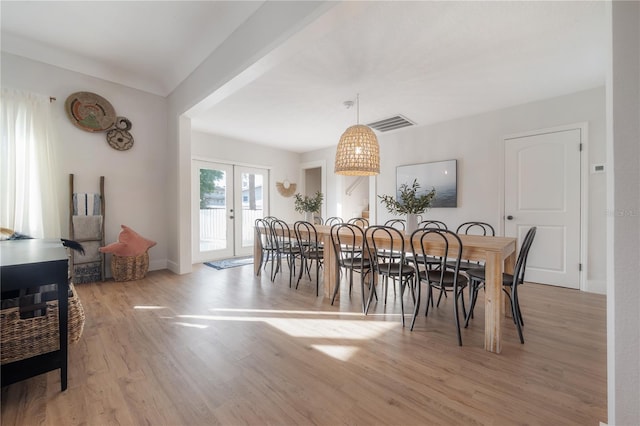 dining space with light wood-type flooring and french doors