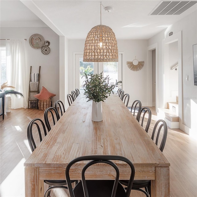 dining area featuring light wood-type flooring and an inviting chandelier